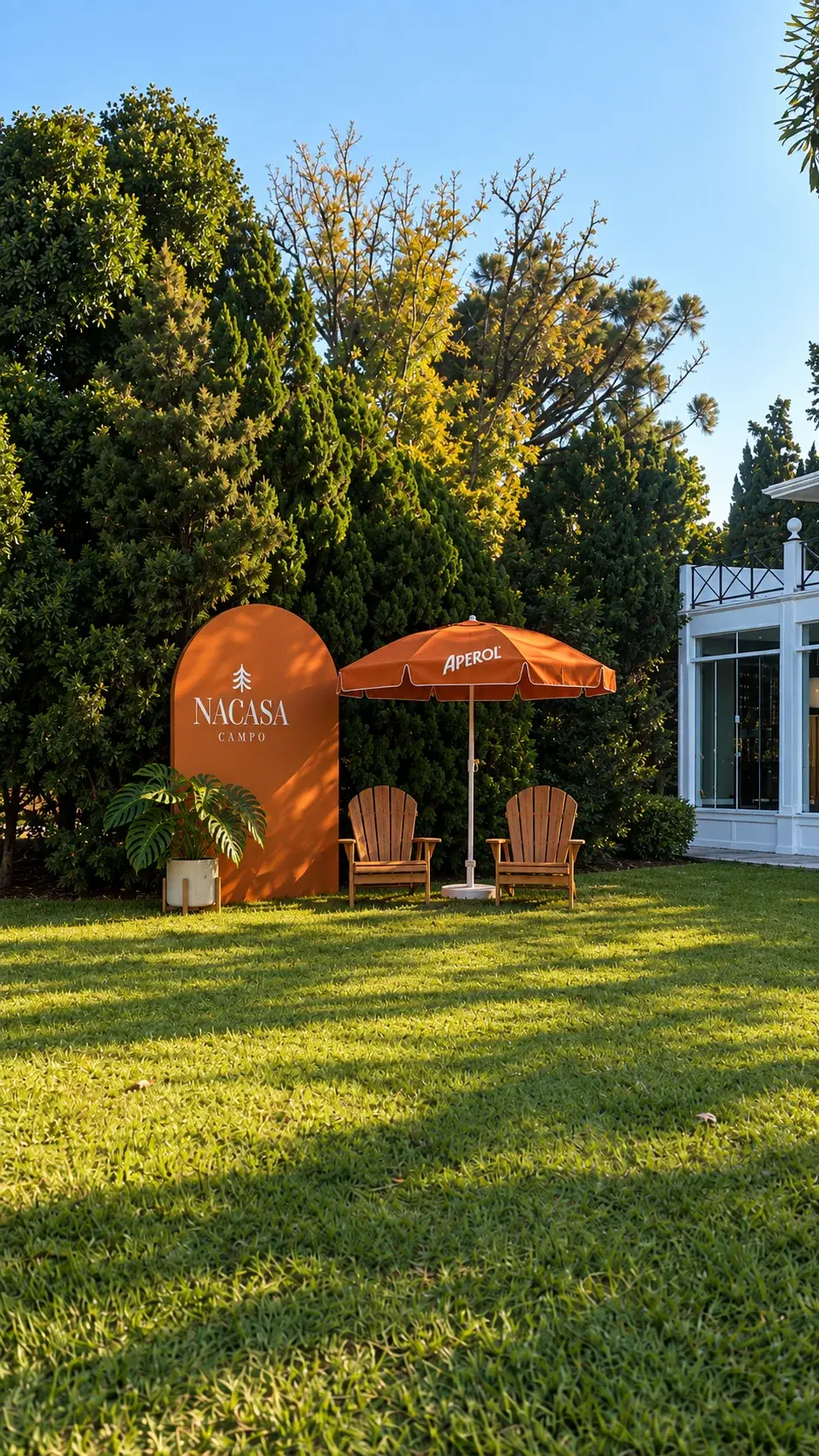 Lounge externo com ombrelone Aperol e painel NaCasa Campo